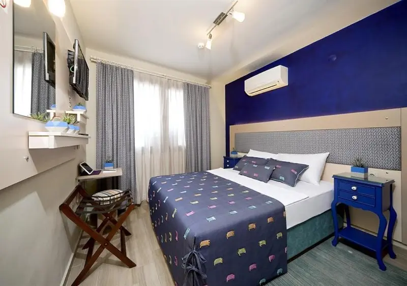 Une chambre avec un lit double et un coin bureau.