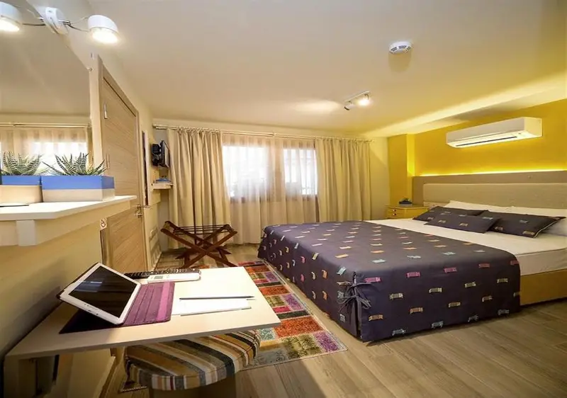 Une chambre lumineuse avec un grand lit et un espace de travail.