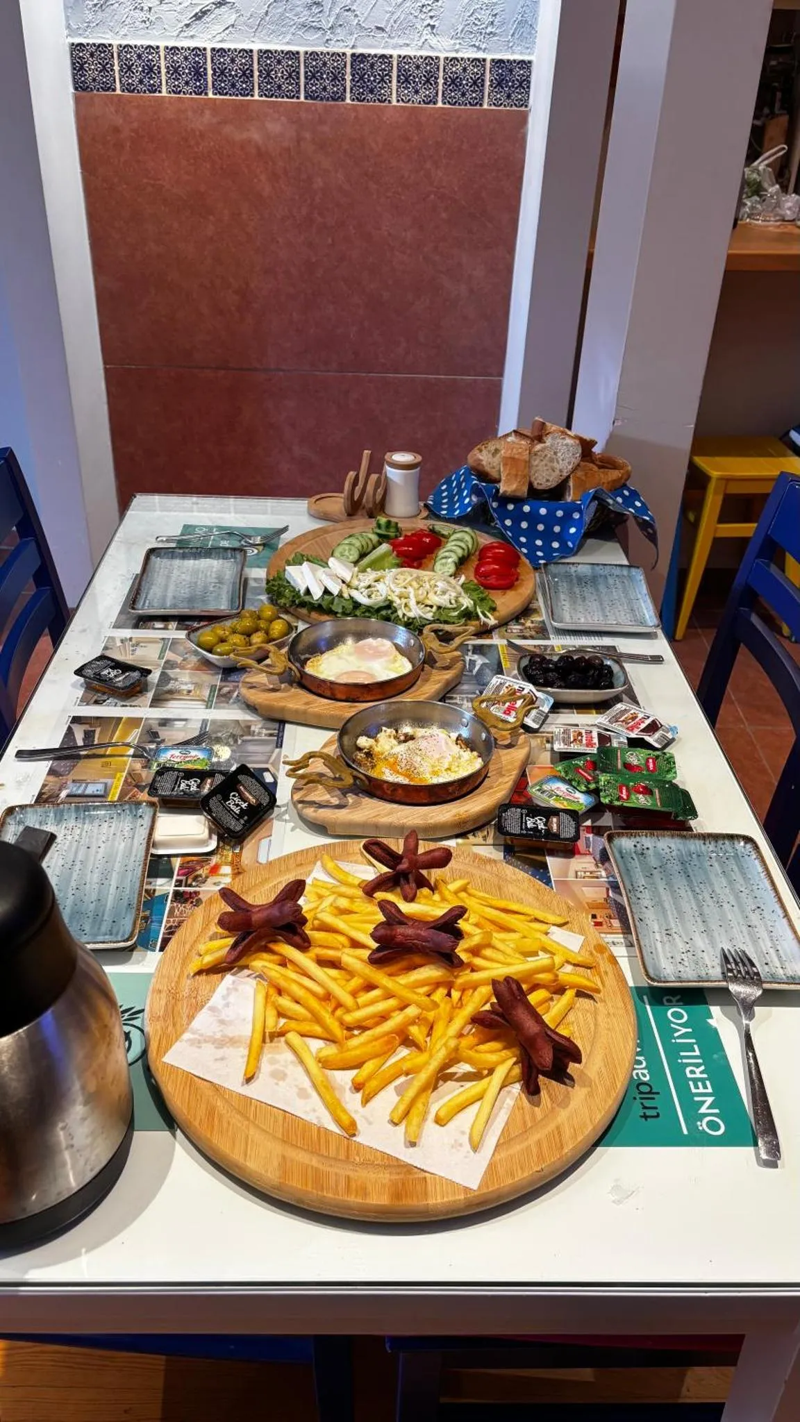 Une table est dressée avec une grande variété de plats et de boissons.