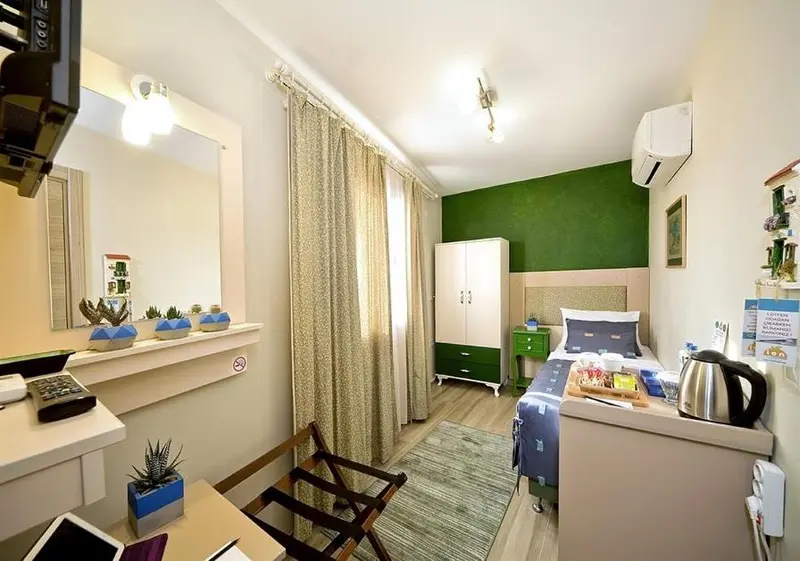 Une chambre lumineuse avec un lit simple et un bureau.
