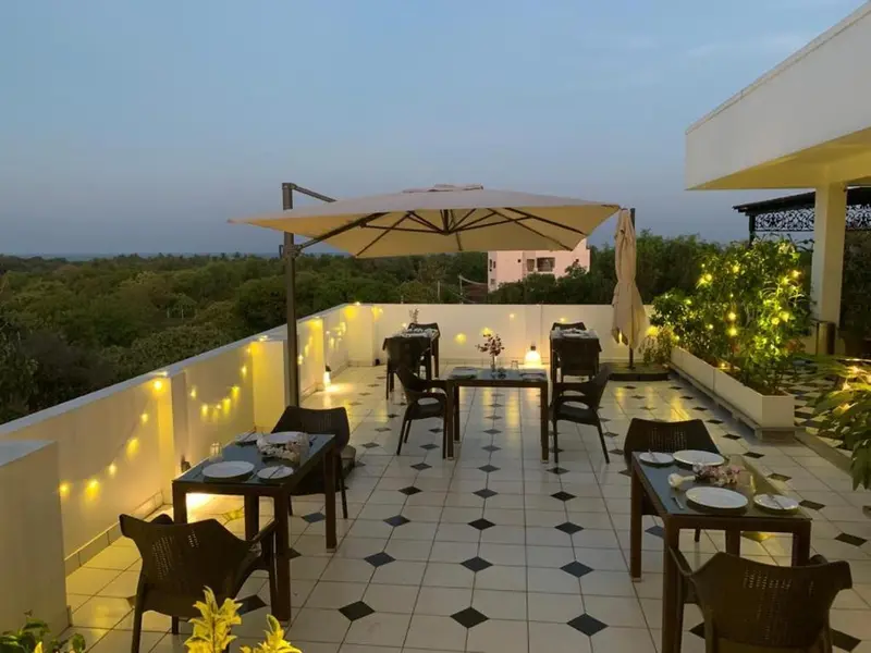 Terrasse aménagée avec tables et chaises pour dîner en extérieur.