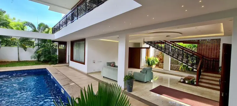 Espace intérieur lumineux avec piscine et végétation luxuriante.