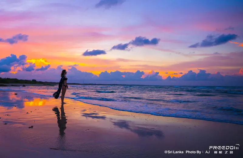 Une personne se promène sur une plage au coucher du soleil.