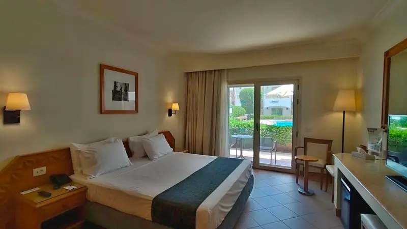 Une chambre lumineuse avec un grand lit et un accès à une terrasse.