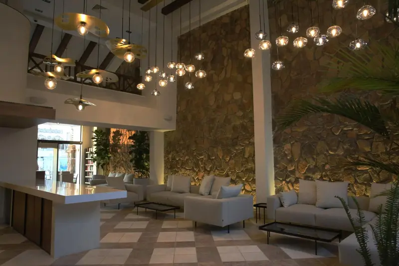 Un hall d'accueil lumineux avec un comptoir et des canapés.