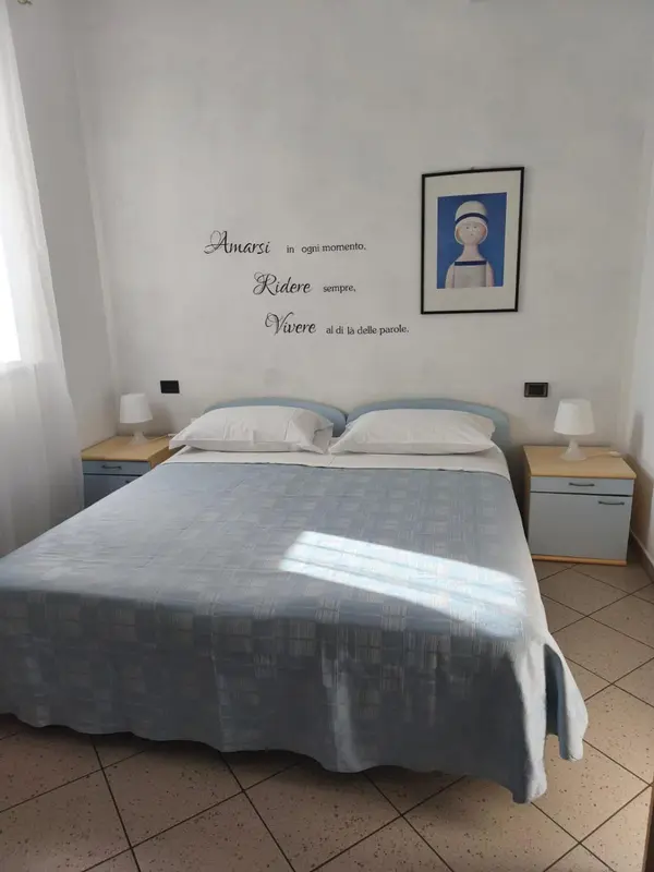 Une chambre lumineuse avec un grand lit et des tables de chevet.