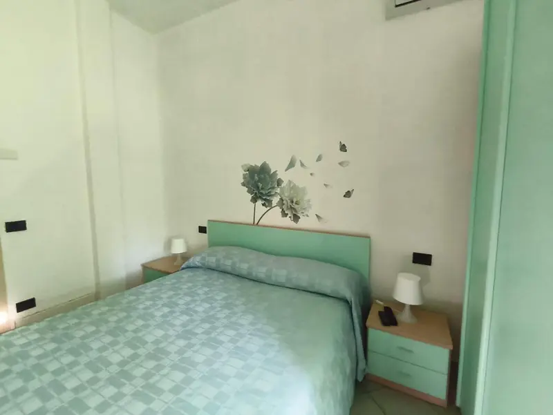 Une chambre lumineuse avec un lit recouvert d'une couverture à motifs.