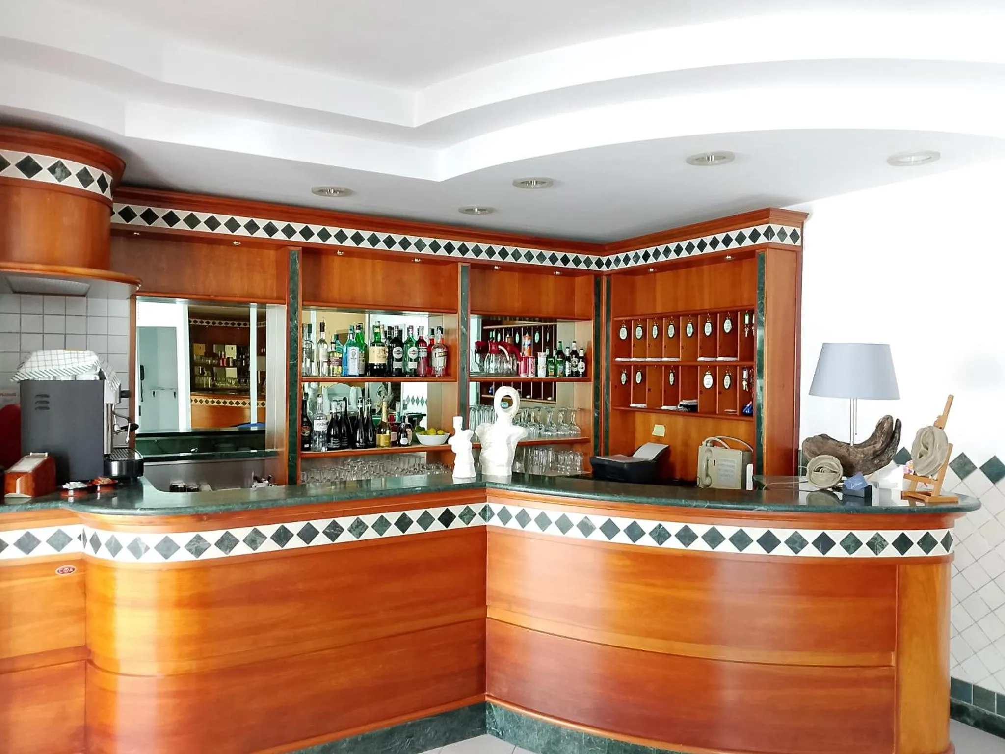 Un comptoir de bar en bois avec des bouteilles et des verres.