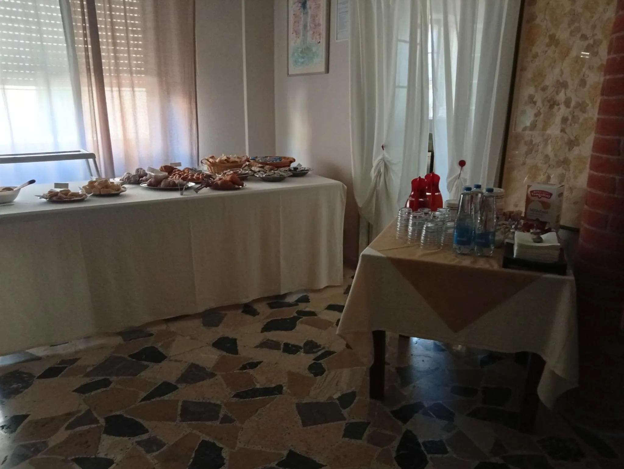 Une table garnie de mets et de boissons est présentée dans une salle lumineuse.