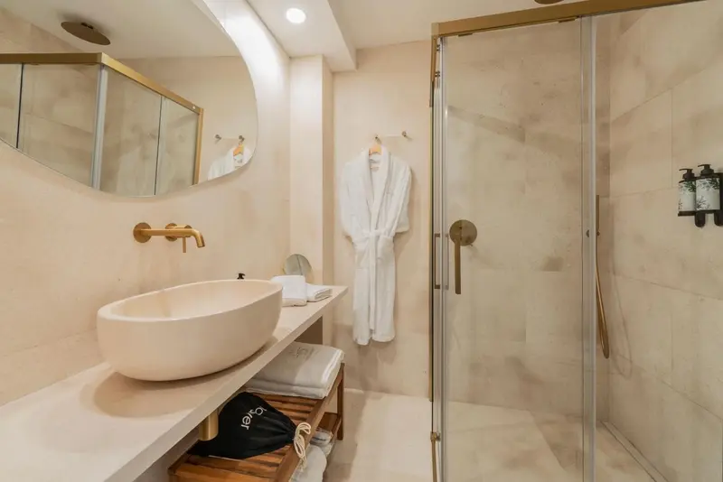 Une salle de bain moderne avec une douche à l'italienne et un lavabo surmonté d'un miroir.