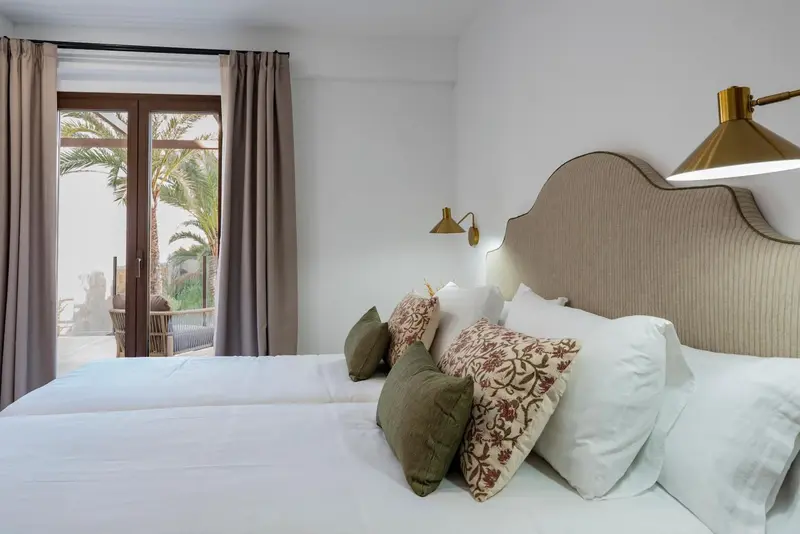 Une chambre lumineuse avec un grand lit et un accès à une terrasse.