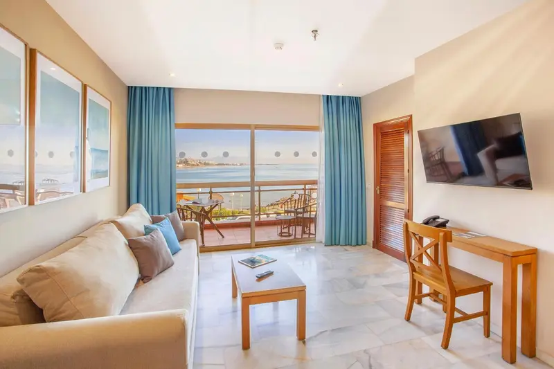 Un salon lumineux s'ouvre sur une terrasse avec vue sur la mer.
