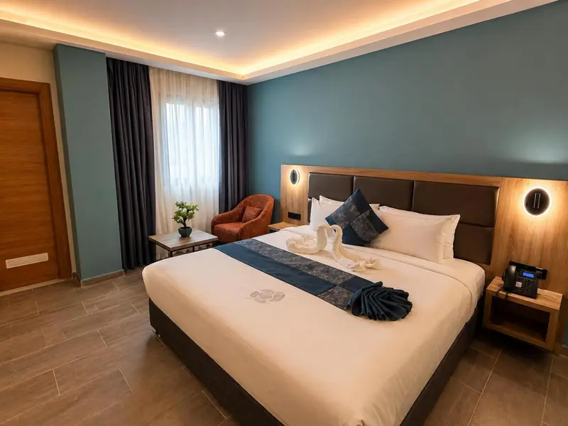 Une chambre lumineuse avec un grand lit et un fauteuil.