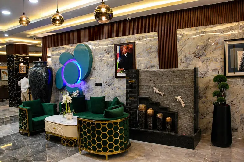 Un hall d'accueil moderne avec un canapé vert et une fontaine décorative.