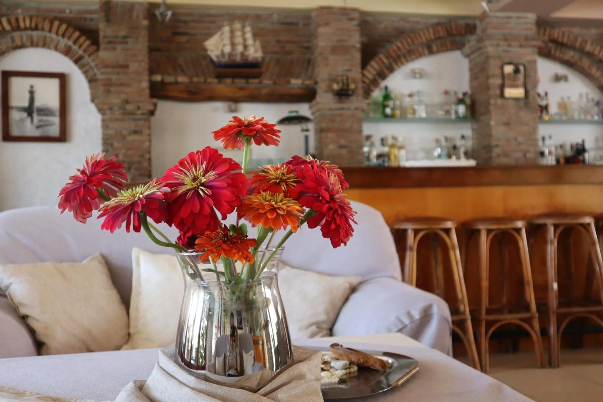 Un bouquet de fleurs colorées illumine un espace de détente avec un bar en arrière-plan.
