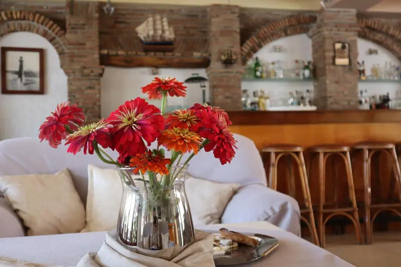 Un bouquet de fleurs colorées illumine un espace de détente avec un bar en arrière-plan.