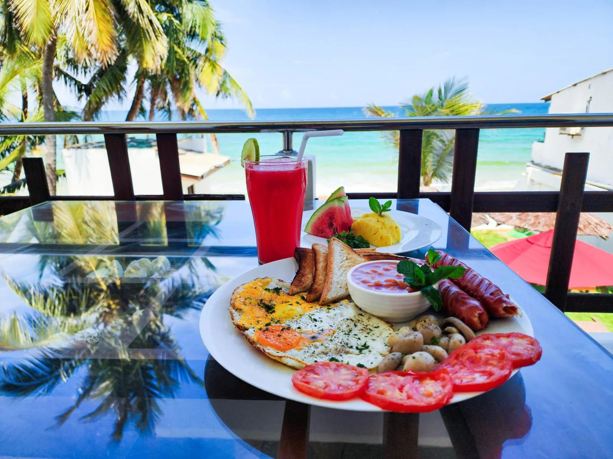 Un copieux petit-déjeuner est servi sur une terrasse avec vue sur la mer.