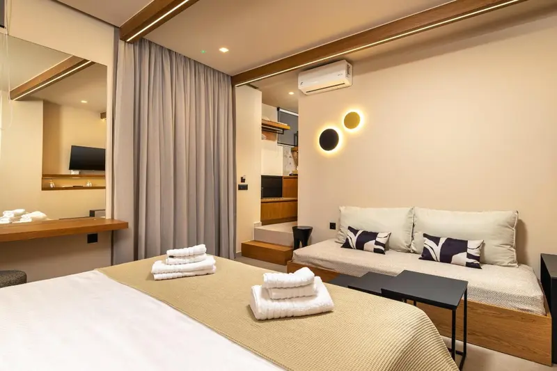 Une chambre avec un lit et un canapé offre un espace de détente lumineux.