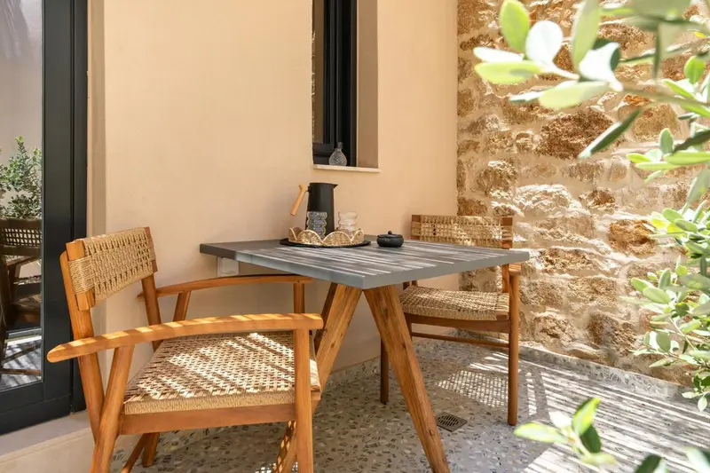 Une table et des chaises en osier invitent à la détente sur une terrasse.