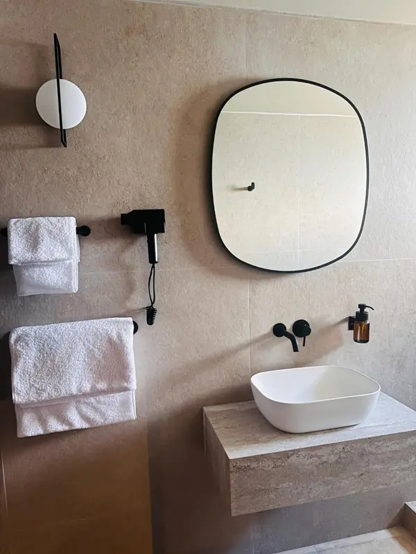 Une salle de bain moderne avec un lavabo blanc et des serviettes.