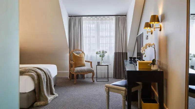 Une chambre lumineuse avec un coin lecture et une coiffeuse.
