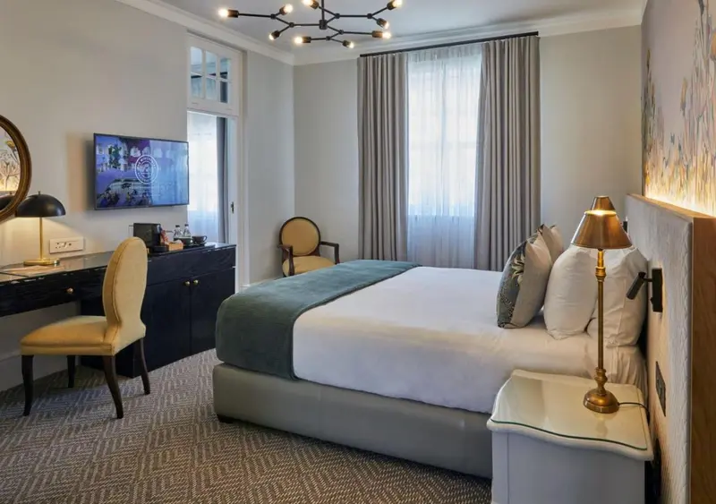 Une chambre d'hotel avec un lit double et un bureau.