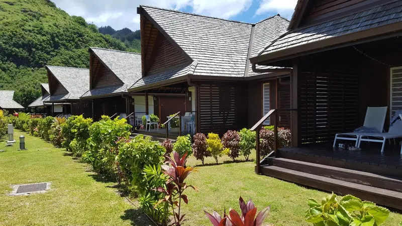 Des bungalows en bois avec terrasses donnant sur un jardin tropical.