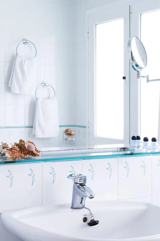 Une salle de bain lumineuse avec une baignoire et des serviettes blanches.