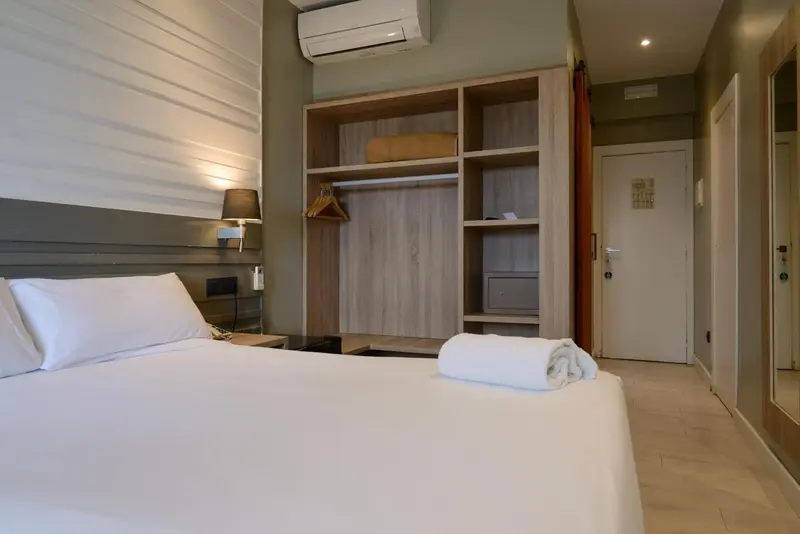 Une chambre lumineuse avec un grand lit et un placard intégré.