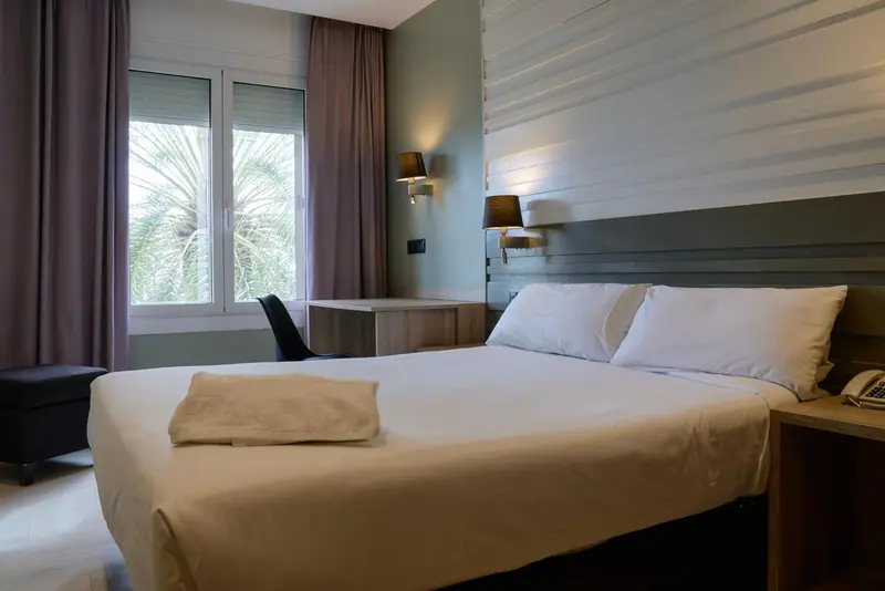 Une chambre lumineuse avec un grand lit et une fenêtre.