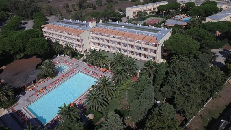 Vue aérienne d'un complexe hôtelier avec piscine et végétation luxuriante.