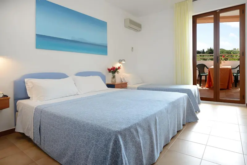 Chambre lumineuse avec un grand lit et un accès à une terrasse.