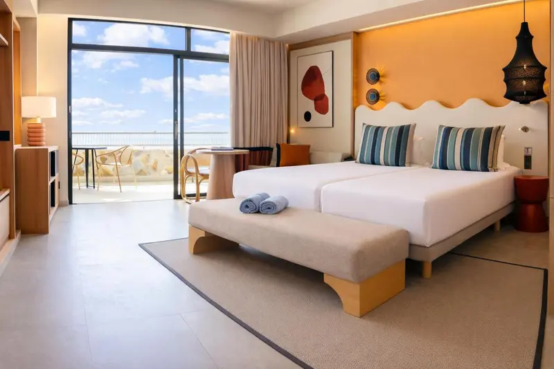Une chambre lumineuse avec un grand lit et une vue sur la mer.