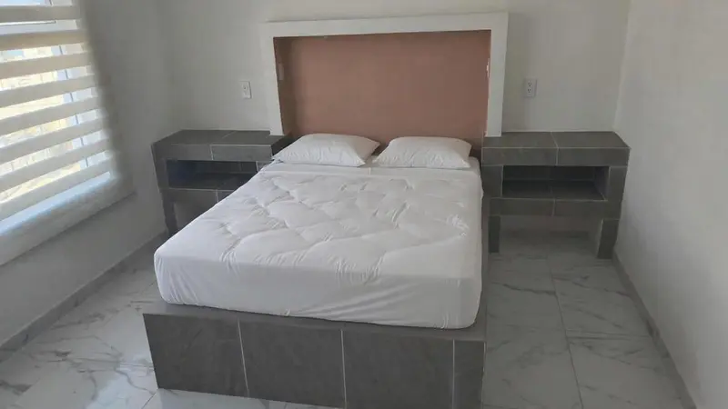 Une chambre avec un lit double et des tables de chevet.
