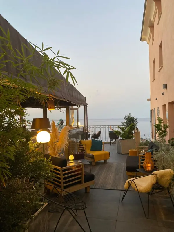 Espace de détente extérieur avec mobilier confortable et vue sur la mer.