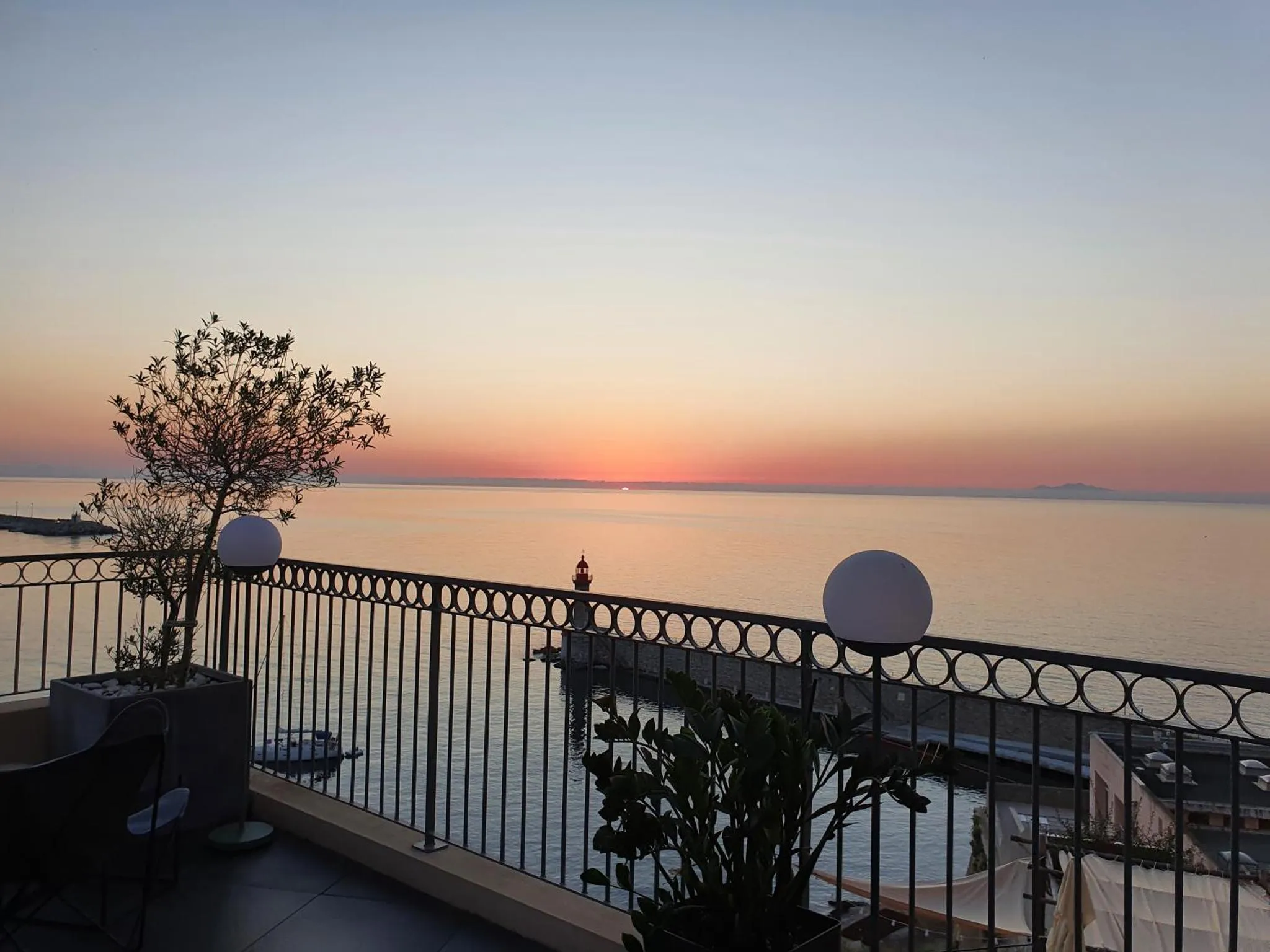 Terrasse avec vue sur la mer au coucher du soleil.