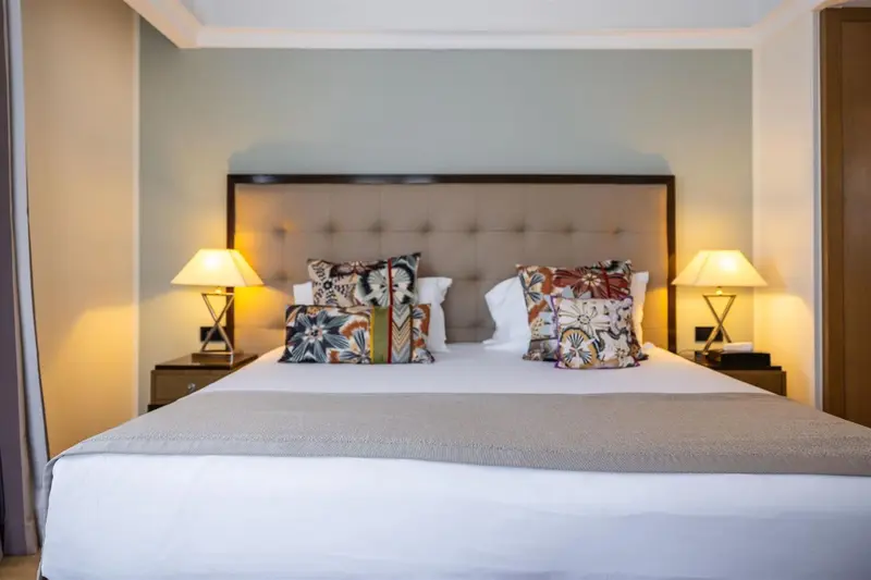 Un lit double avec des oreillers décoratifs dans une chambre lumineuse.