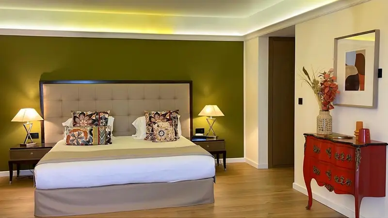 Une chambre lumineuse avec un grand lit et une décoration florale.
