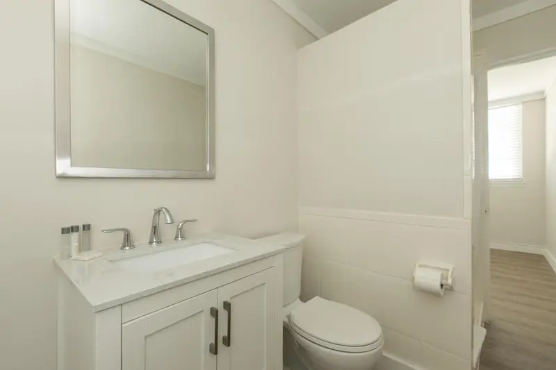Une salle de bain claire avec un lavabo et des toilettes.