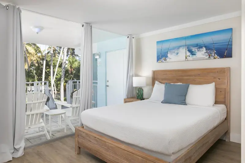 Une chambre lumineuse avec un grand lit et un accès à une terrasse.