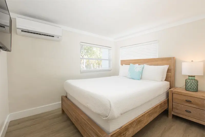 Une chambre lumineuse avec un lit double et une fenêtre.