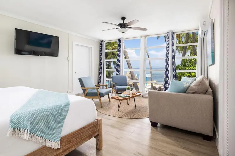 Une chambre lumineuse avec un canapé et un lit donnant sur une vue sur la mer.