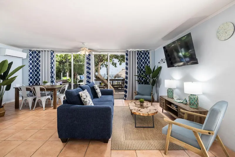Un salon lumineux s'ouvre sur une terrasse avec vue sur la végétation.