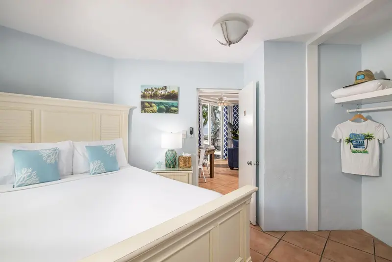 Une chambre lumineuse avec un grand lit recouvert d'une courtepointe blanche.