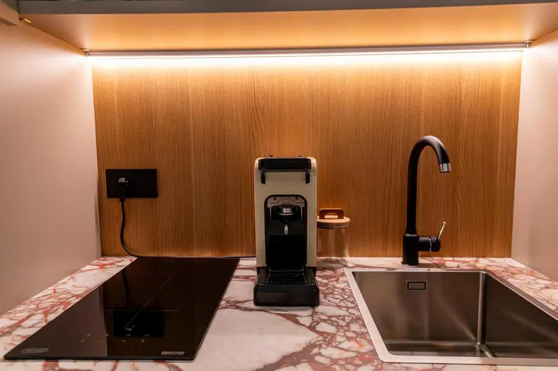 Une machine à café et un robinet d'évier sur un plan de travail.