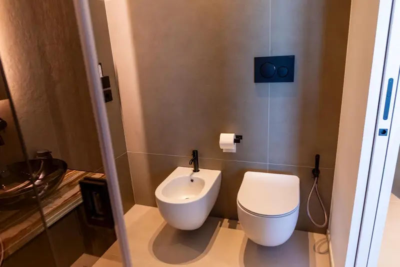 Une salle de bain moderne avec des sanitaires suspendus et un carrelage beige.