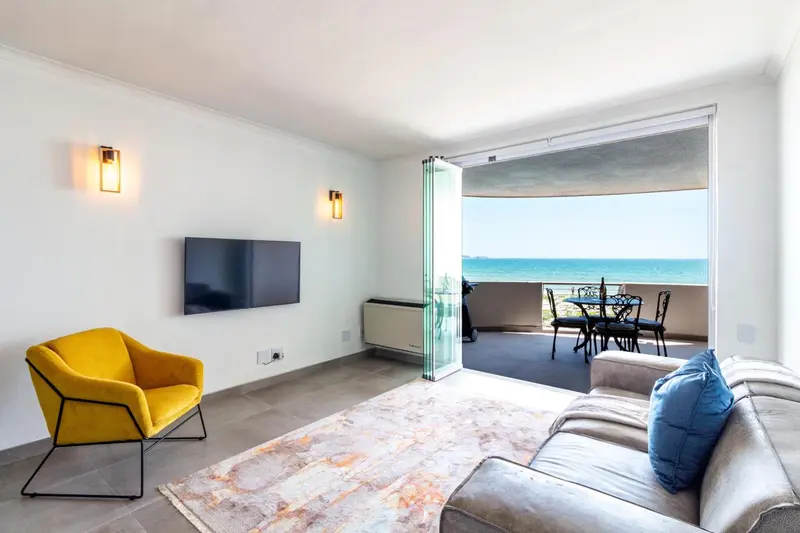 Un salon lumineux s'ouvre sur une terrasse avec vue sur la mer.