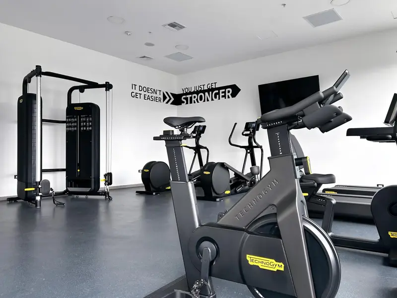 Une salle de sport lumineuse avec des équipements de musculation et des vélos d'appartement.