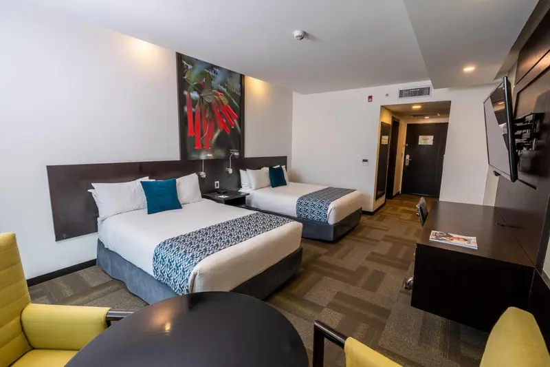 Une chambre d'hôtel moderne avec deux lits et un bureau.