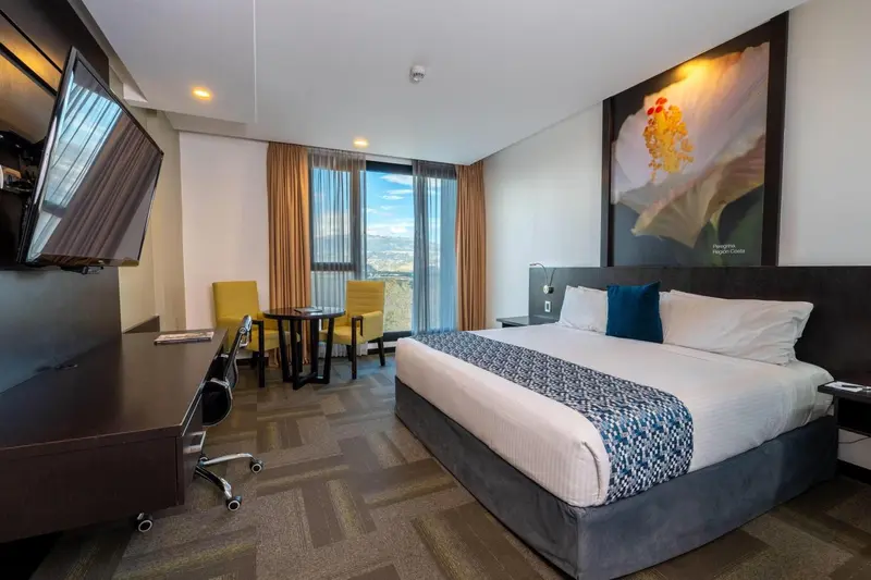 Une chambre d'hôtel moderne avec un grand lit et un coin repas.